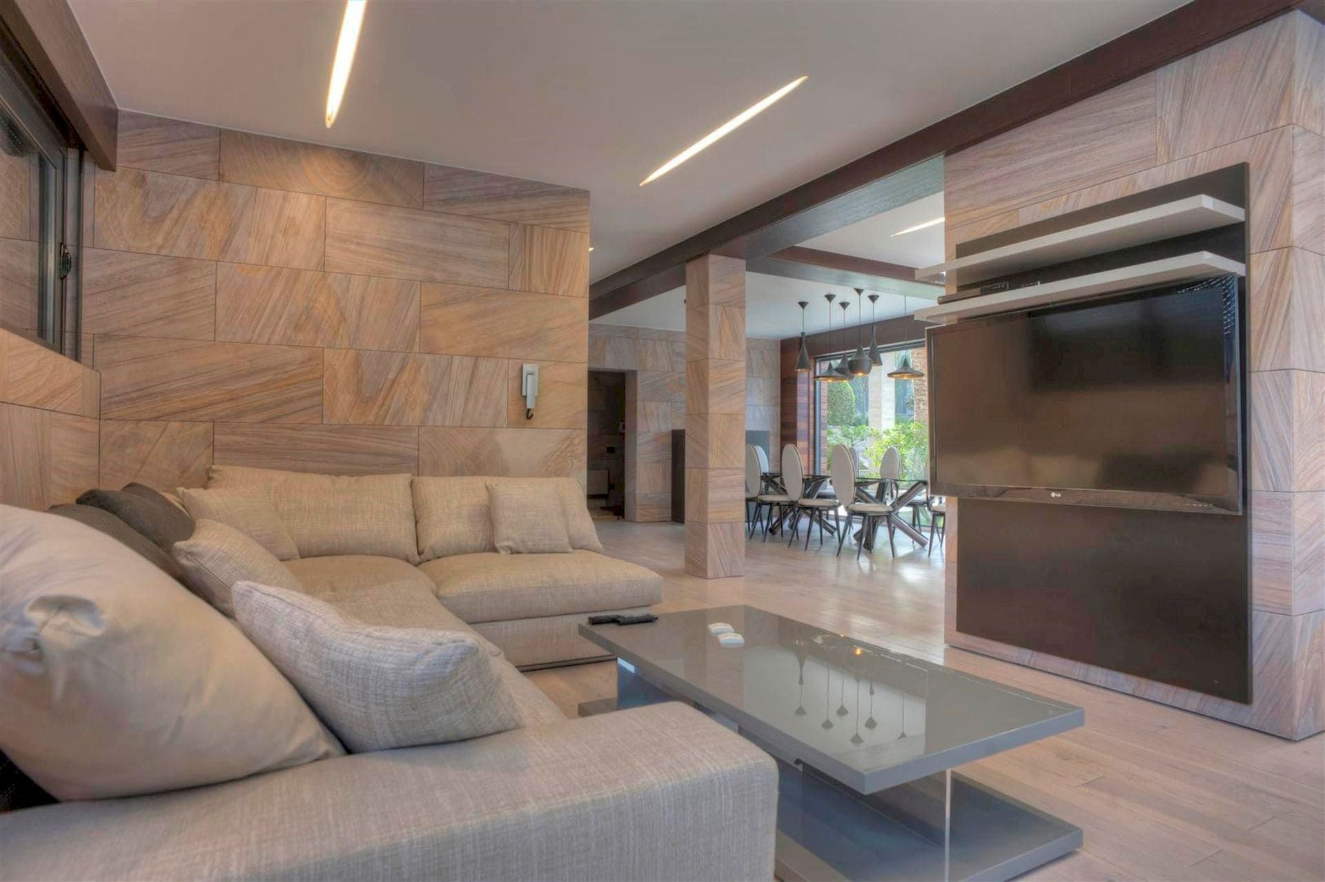 Salon avec finition en pierre, canapé moelleux et coin TV dans une villa à Krašići, Monténégro.