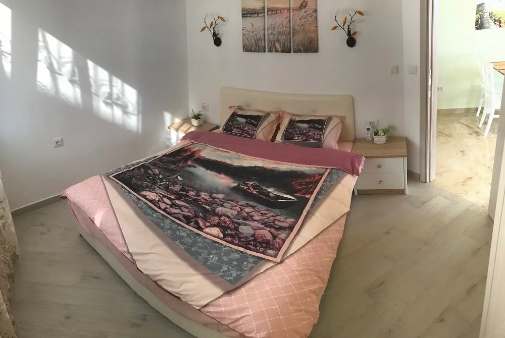Cozy bedroom with a double bed in an apartment in Dobri Vody, Montenegro: bright interior and modern furniture.