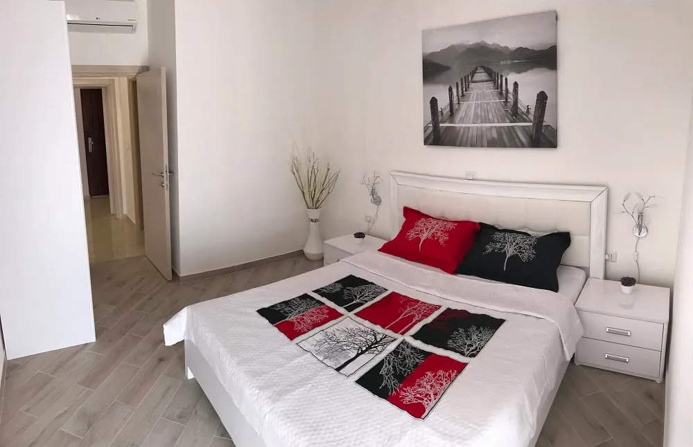Bright bedroom in an apartment, Dobri Vody, Montenegro: double bed, modern furniture and decor in the interior.
