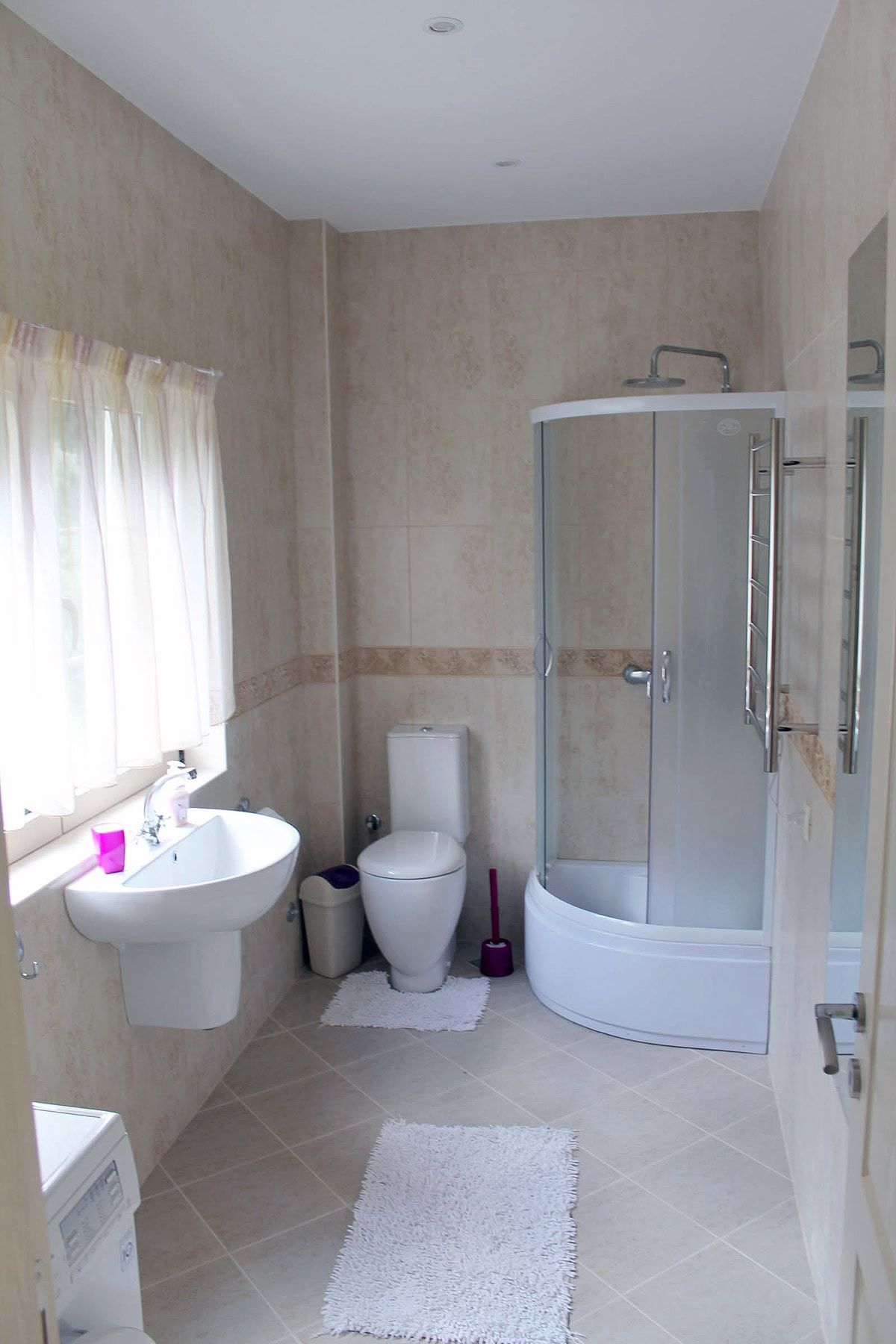 Prčanj, Karadağ’daki dairede duş kabinli aydınlık banyo: fayanslar, sıhhi tesisat ve perdeli pencere.
