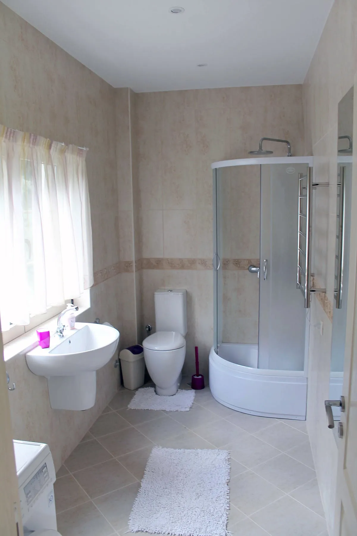 Prčanj, Karadağ’daki dairede duş kabinli aydınlık banyo: fayanslar, sıhhi tesisat ve perdeli pencere.