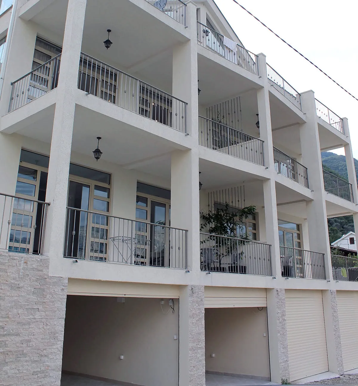 Karadağ, Prčanj’de balkonlu ve garajlı modern bir konut binasının cephesi: çok daireli gayrimenkulün görünümü.