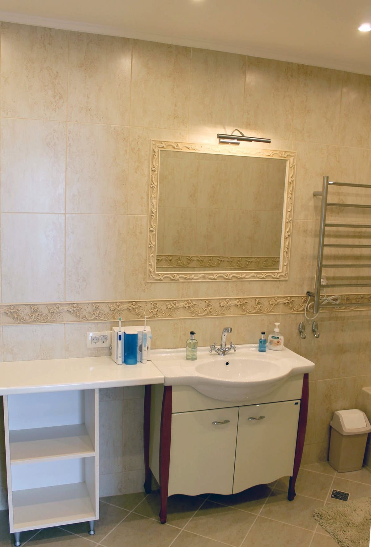 Prčanj, Karadağ’daki dairede aydınlık banyo: bej fayanslar, lavabolu dolap, ayna ve havlupan.