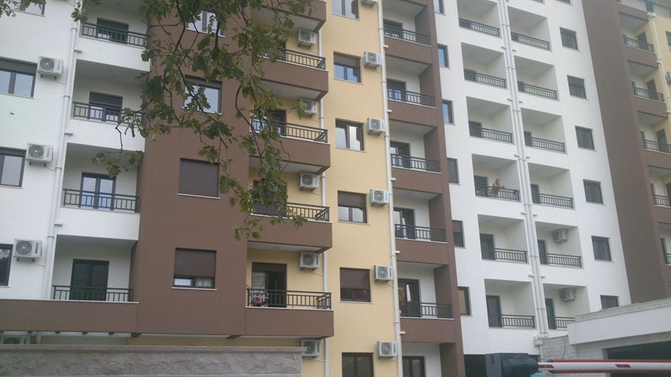 Karadağ, Budva'daki modern konut kompleksinin cephesi: balkonları ve dış klima üniteleri olan çok katlı bina.