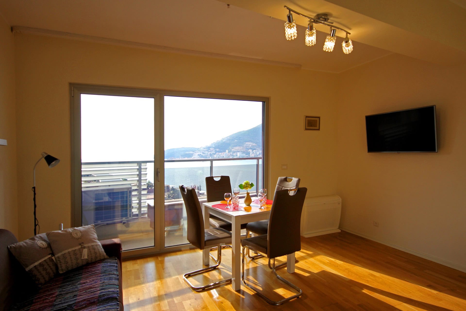 Wohnzimmer mit Essbereich und Panoramablick auf das Meer in einer Wohnung in Bečići, Montenegro: moderne Möbel und Parkett.