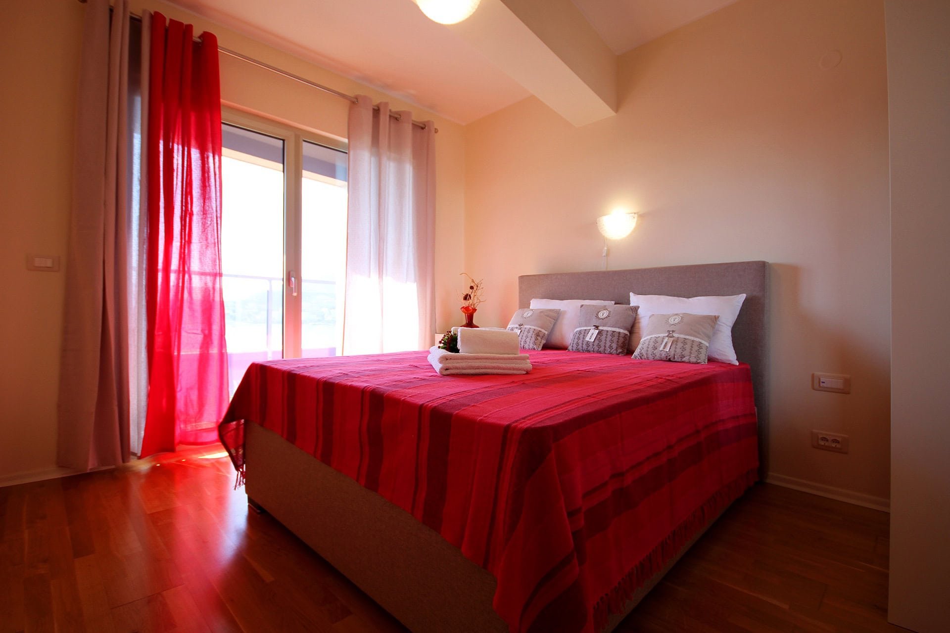 Gemütliches Schlafzimmer mit Doppelbett und Zugang zum Balkon in einer Wohnung, Bečići, Montenegro.