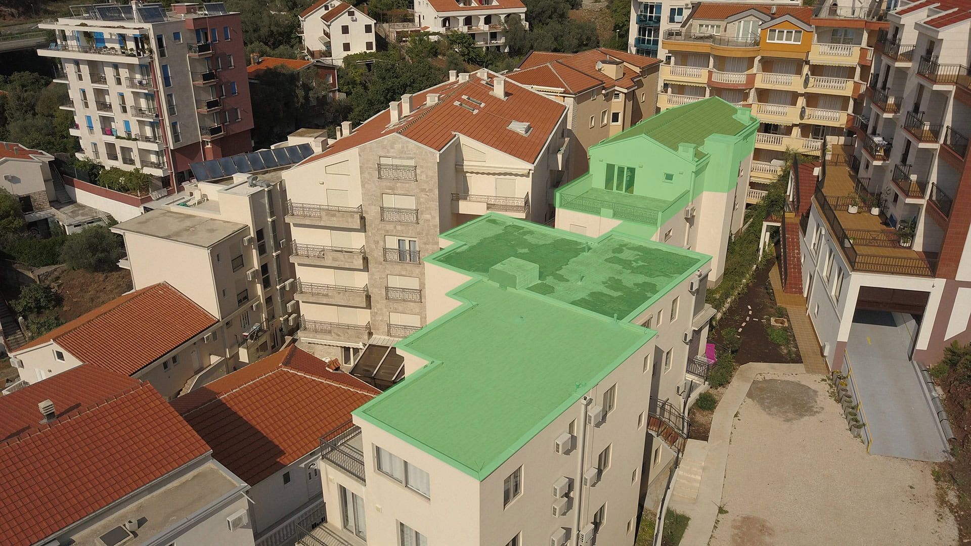 Aerial view of a residential complex with green roofs in Pržno, Montenegro: modern apartments and penthouses.