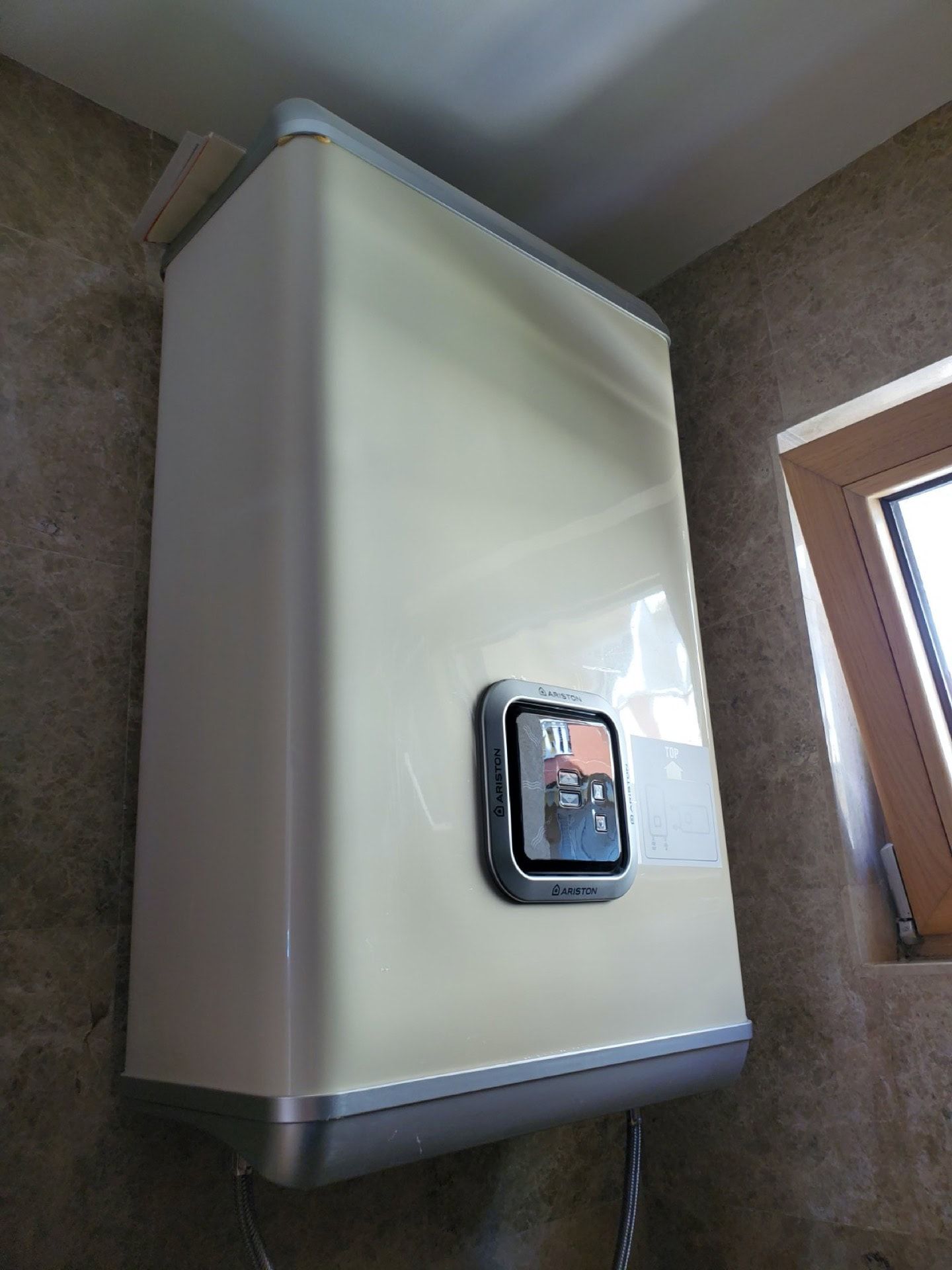 Ariston electric water heater in the penthouse bathroom in Pržno, Montenegro, against marble-look tiles.