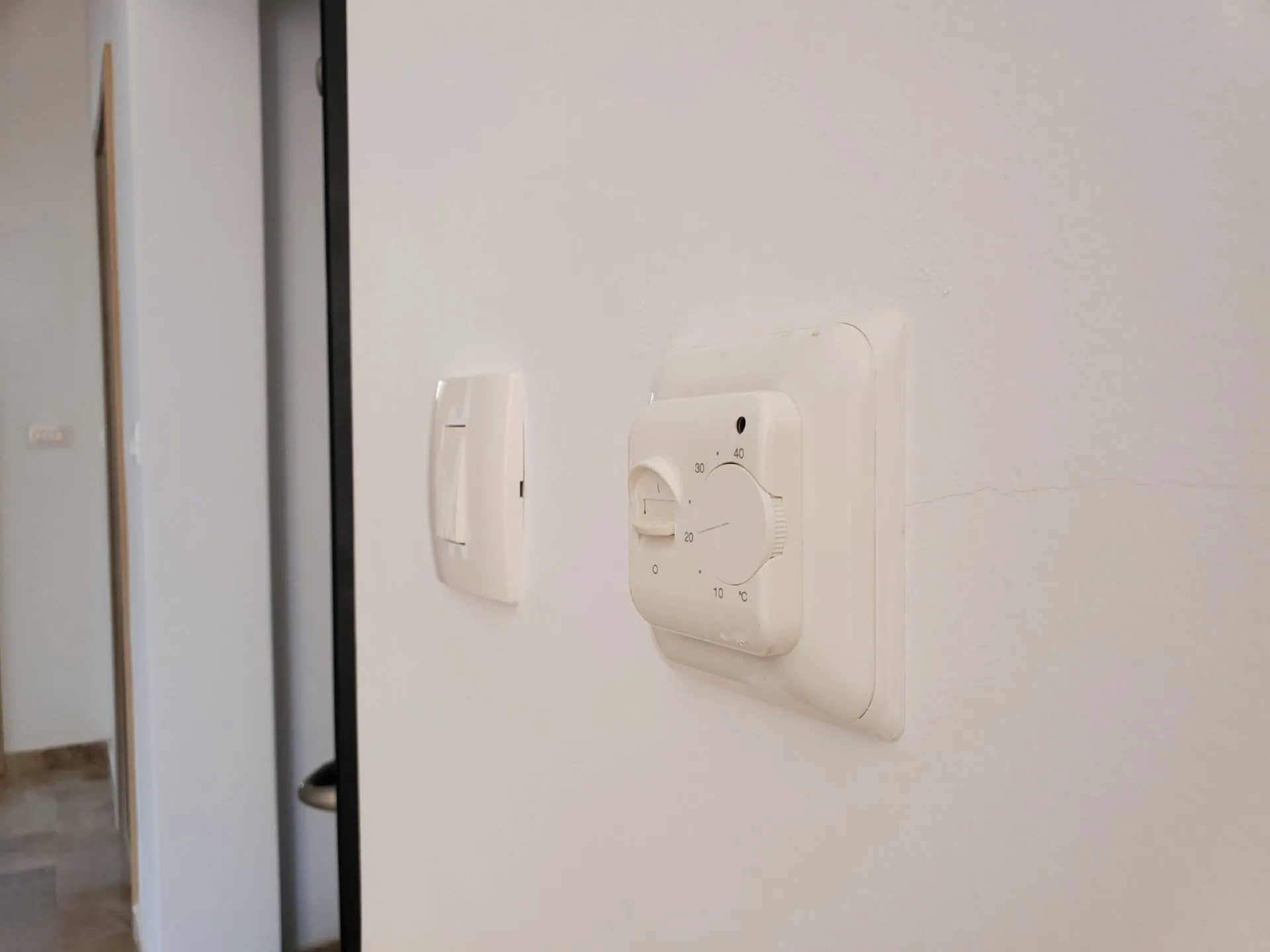 Pržno, Karadağ’daki dairede yerden ısıtma termostatı ve ışık anahtarı. Penthouse’ta iklim kontrolü.