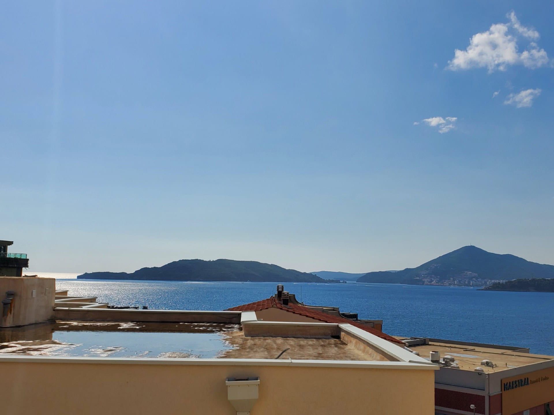 Panoramic view of the Adriatic Sea and mountains from the penthouse terrace in Pržno, Montenegro, on a clear sunny day.