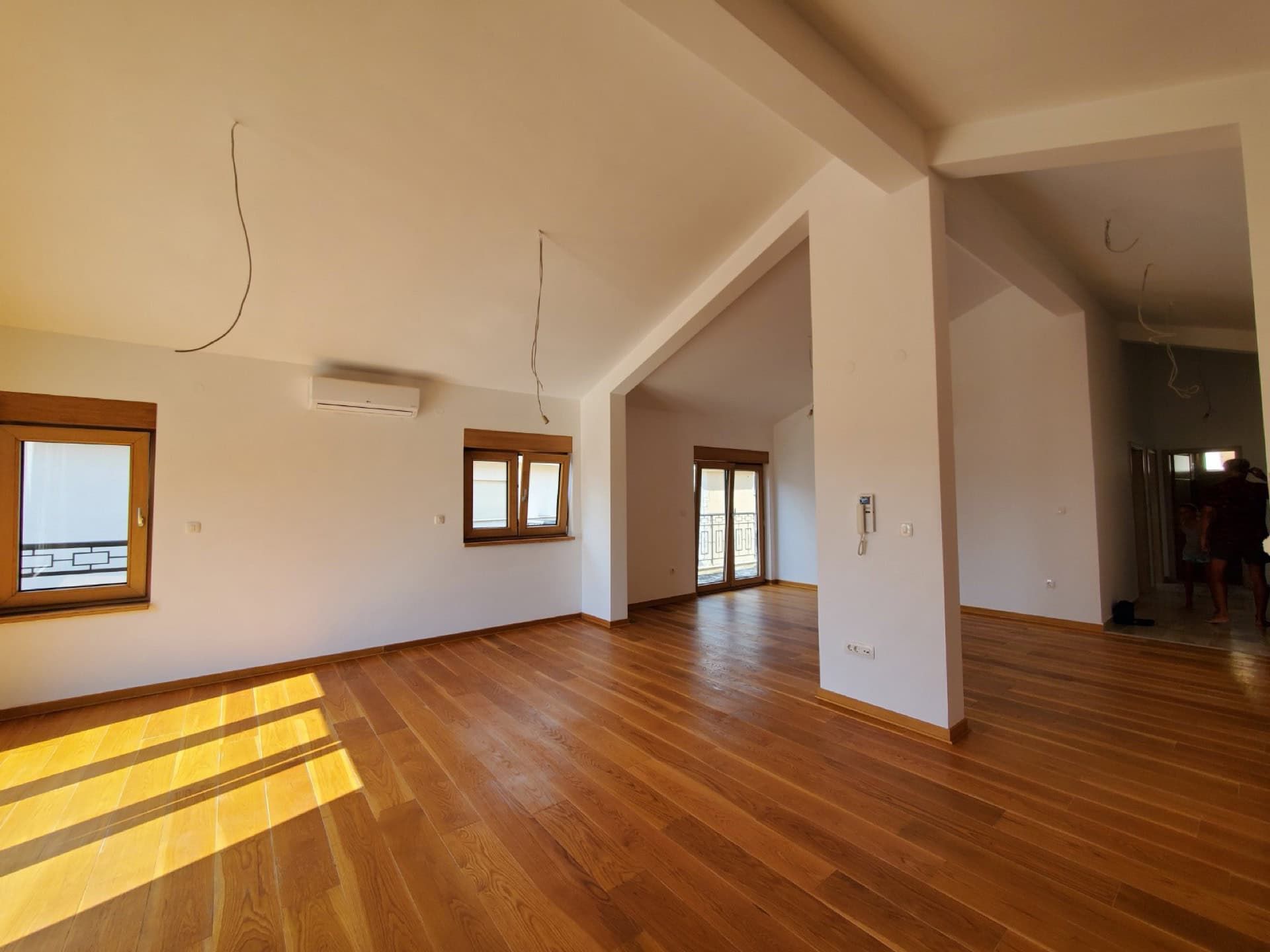 Spacious living room in a penthouse, Pržno, Montenegro: light finishes, wooden floor, air conditioning, and panoramic windows.