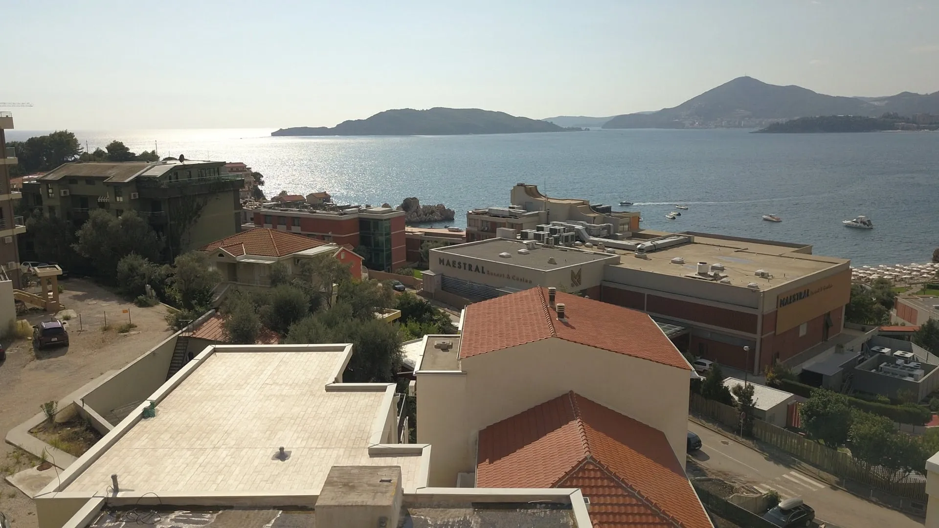 Pržno, Karadağ’daki penthouse’tan deniz ve Maestral otelinin panoramik manzarası: evlerin çatıları ve deniz manzarası.