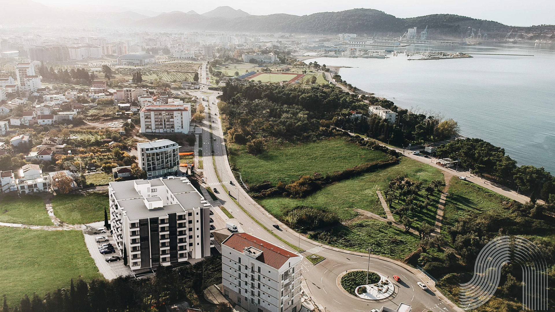 Panoramablick aus der Luft auf eine Wohnanlage in der Stadt Bar, Montenegro, mit Meeresküste und städtischer Infrastruktur.