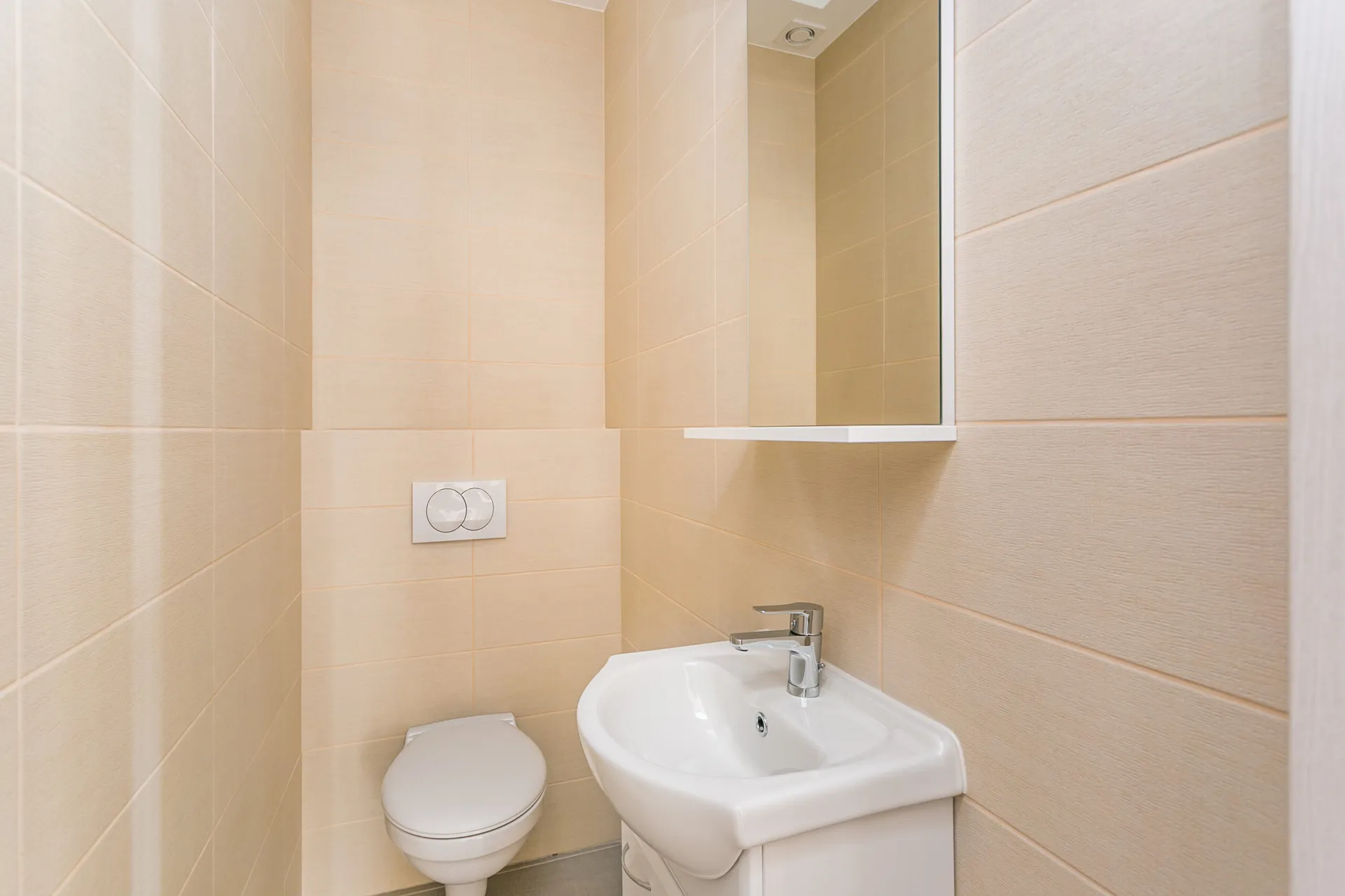 Modernes Badezimmer im Penthouse, Rafailovići, Montenegro: beige Fliesen, Hänge-WC und Waschbecken.