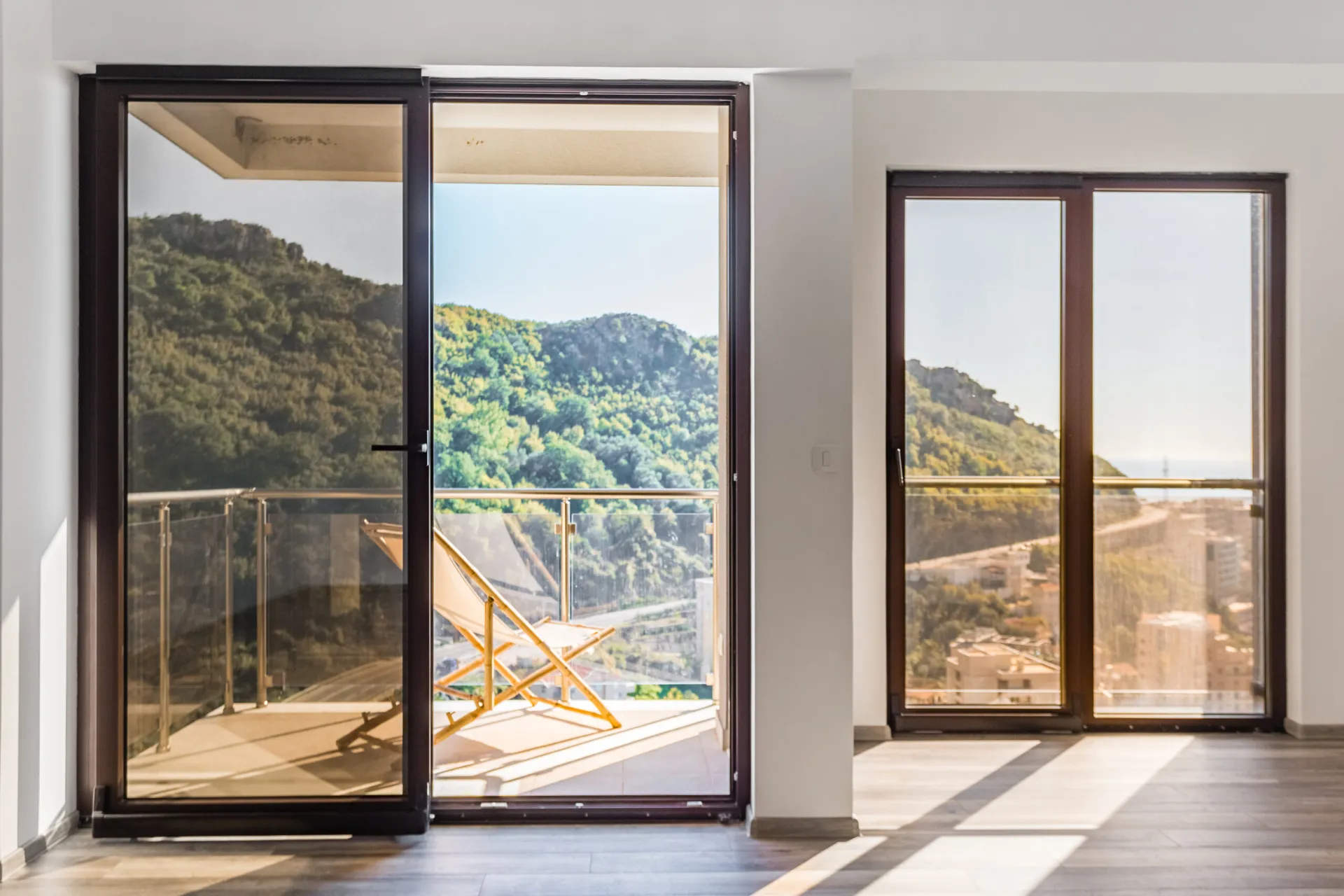 Wohnzimmer im Penthouse in Rafailovici, Montenegro: Panoramafenster, Zugang zum Balkon mit Blick auf die Berge und das Meer.