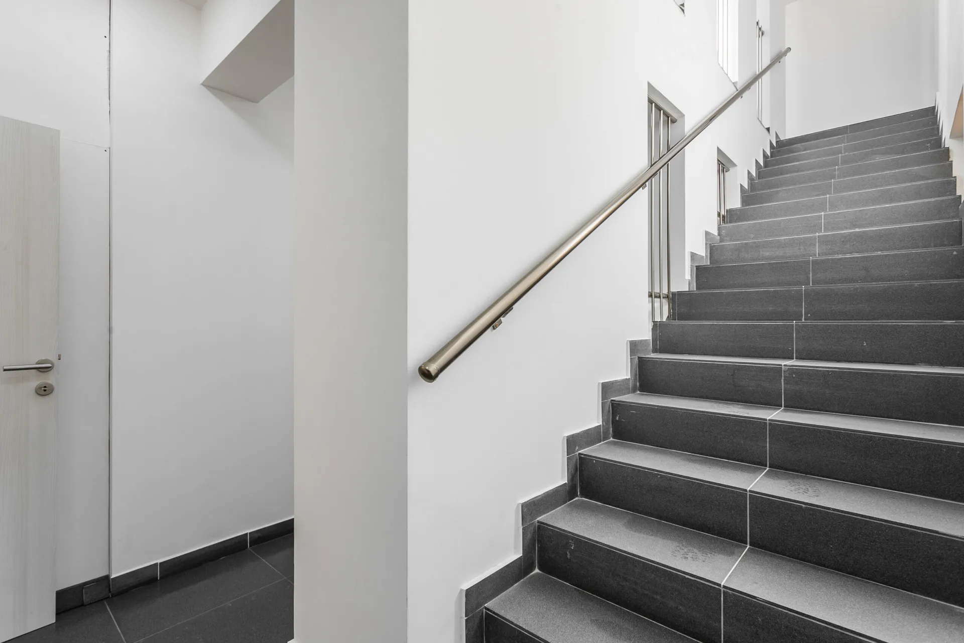 Moderne Treppe mit Verkleidung aus dunklem Feinsteinzeug und Metallgeländern im Penthouse, Rafailovići, Montenegro