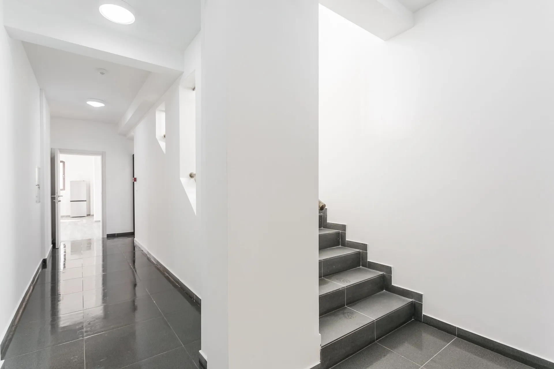 Moderner heller Flur mit grauen Fliesen und Treppe im Penthouse, Rafailovići, Budva-Riviera, Montenegro.
