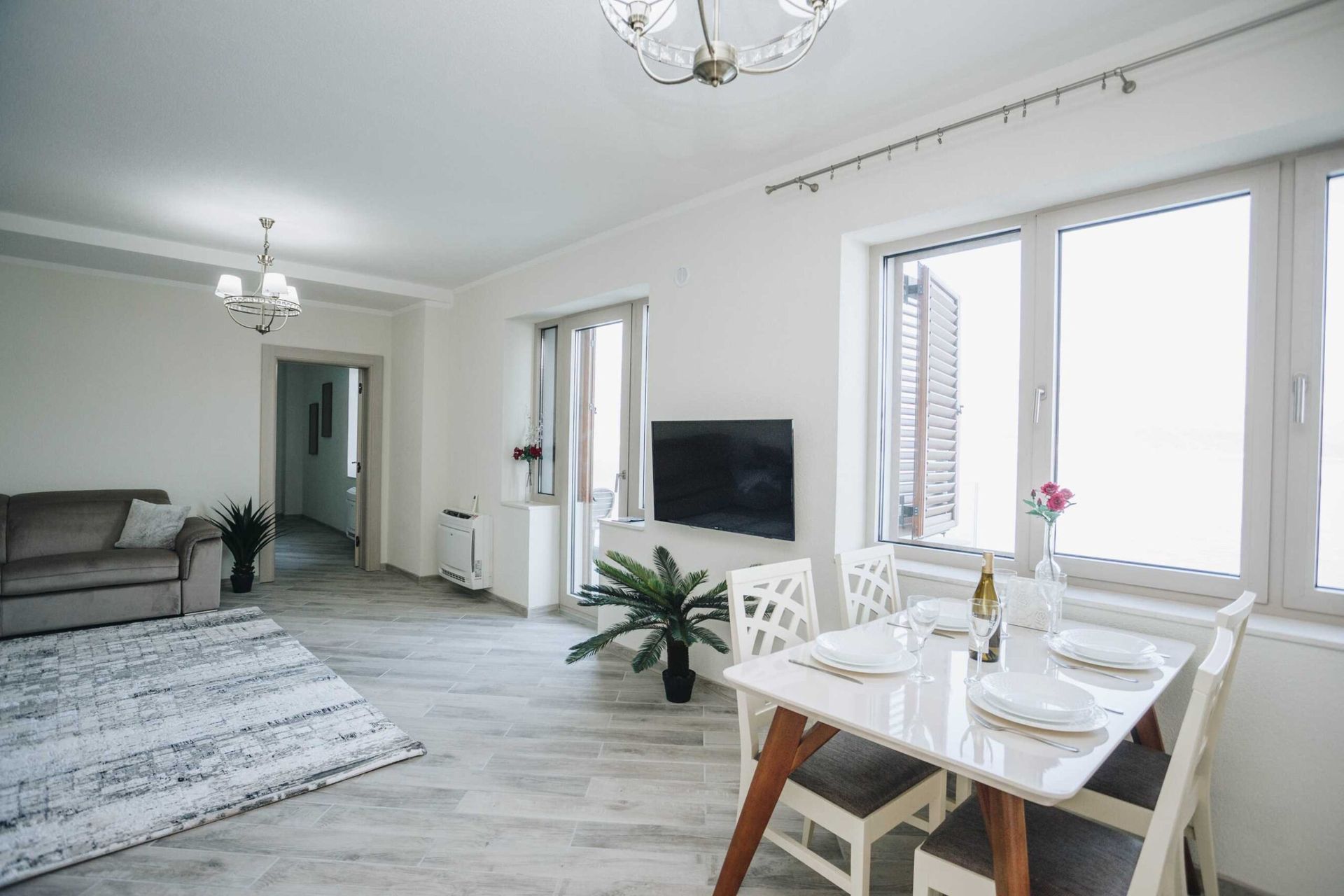 Jasny salon z jadalnią w willi w Krašići, Czarnogóra: nowoczesne meble, panoramiczne okna i dekoracje.