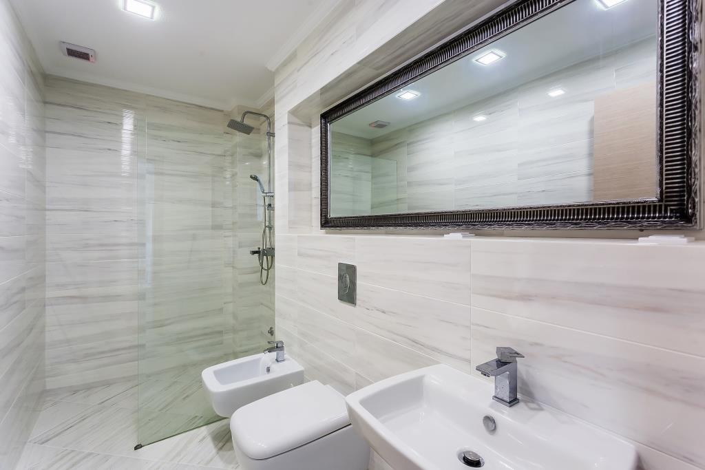 Modern bathroom with a shower cabin and light-colored tiles in a villa in Krašići, Montenegro.