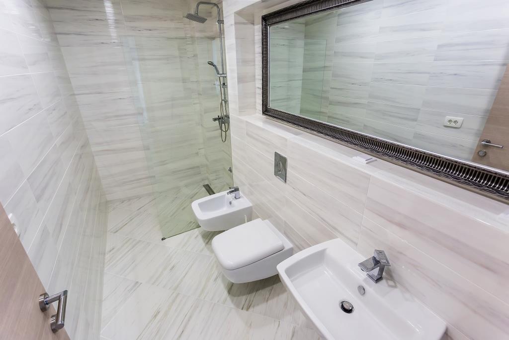 Modern bathroom with a shower cabin and bidet in a villa in Krašići, Montenegro: bright marble-look finishes.