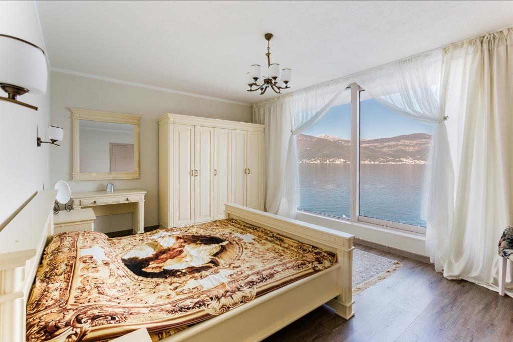 Bedroom in a villa in Krašići, Montenegro: light-colored furniture, a double bed, and panoramic sea and mountain views.