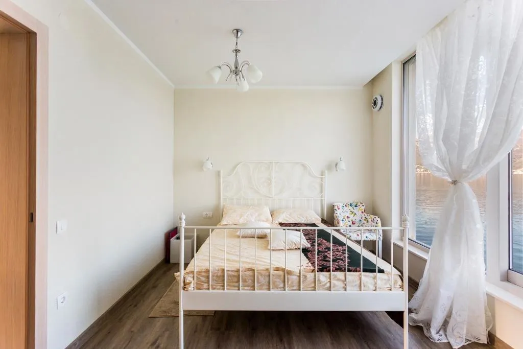 Bright bedroom with a double bed and panoramic sea view in a villa, Krašići, Montenegro.