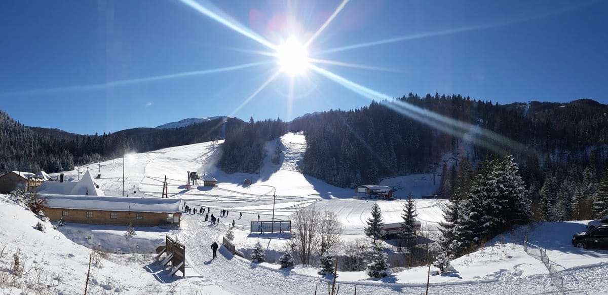 Vue sur la station de ski et l’hôtel K1600 à Kolašin, Monténégro : pistes enneigées, remontées mécaniques et journée ensoleillée.