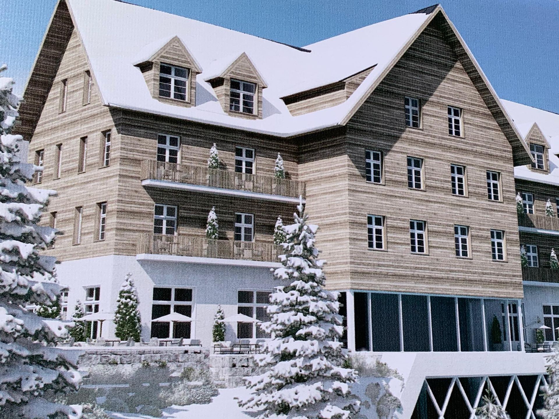 Facade of the Durmitor H&V hotel in Žabljak, Montenegro: a modern wooden building in the mountains, covered in snow in winter.