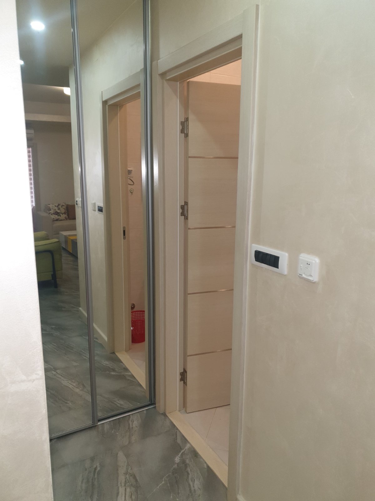 Flur mit Spiegelschiebetürenschrank und hellen Innentüren in einer Wohnung, Stadt Budva, Montenegro.