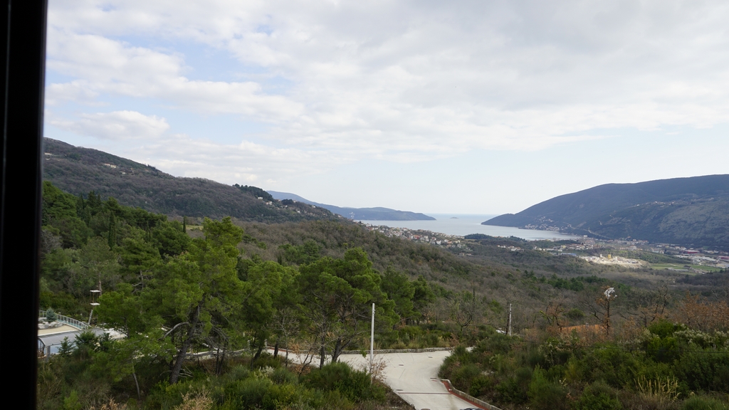 Vue panoramique sur la mer et les montagnes depuis une villa à Igalo, Herceg Novi, Monténégro : collines verdoyantes et baie maritime.