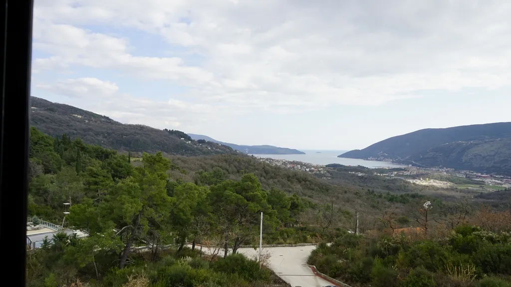 Vue panoramique sur la mer et les montagnes depuis une villa à Igalo, Herceg Novi, Monténégro : collines verdoyantes et baie maritime.