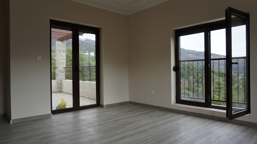 Salon lumineux dans la villa d’Igalo, Monténégro : baies panoramiques, accès à la terrasse et vue sur les montagnes, finition moderne.