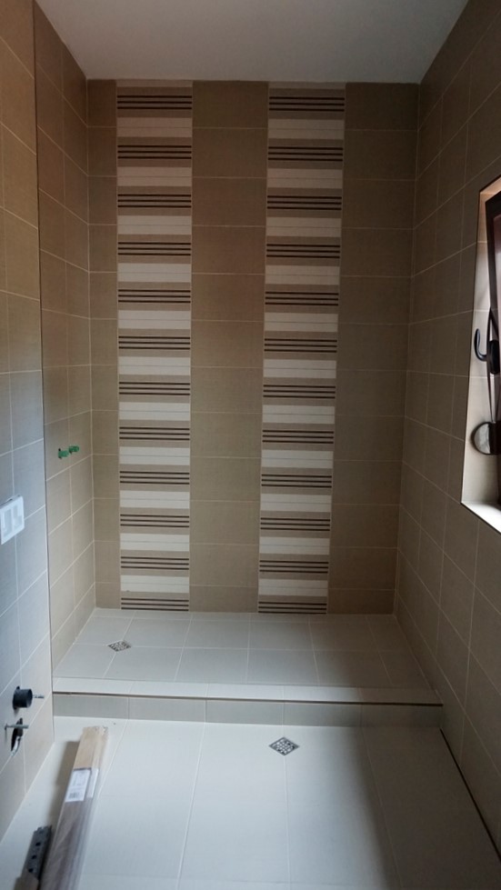 Salle de bains avec douche et carrelage beige dans une villa à Igalo, Monténégro : finition intérieure moderne.