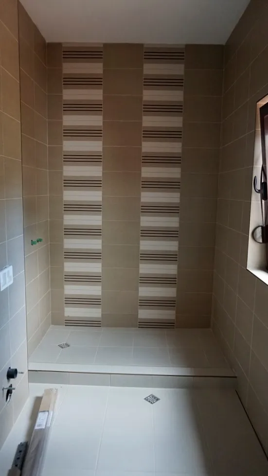 Salle de bains avec douche et carrelage beige dans une villa à Igalo, Monténégro : finition intérieure moderne.