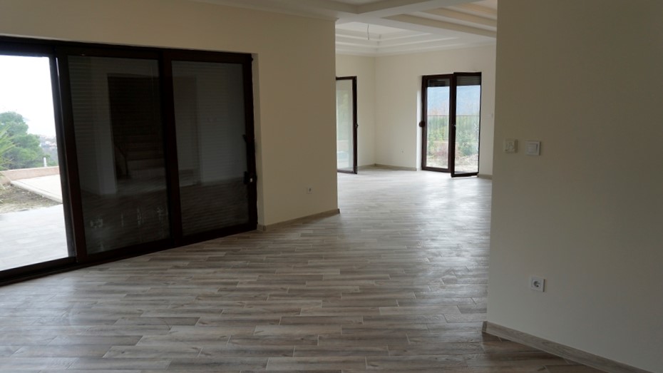 Salon spacieux avec baies vitrées panoramiques et finitions claires dans une villa à Igalo, Monténégro.