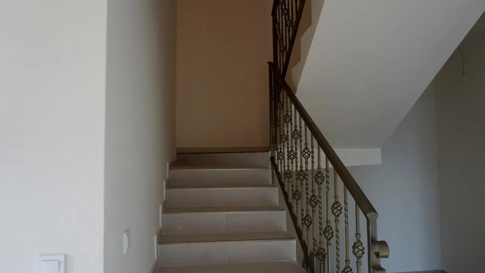 Escalier avec rampe en fer forgé à l’intérieur d’une villa à Igalo, Herceg Novi, Monténégro. Finition moderne dans des tons clairs.