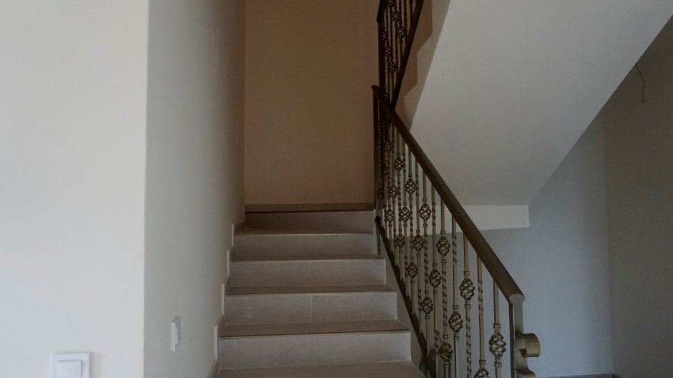 Escalier avec rampe en fer forgé à l’intérieur d’une villa à Igalo, Herceg Novi, Monténégro. Finition moderne dans des tons clairs.