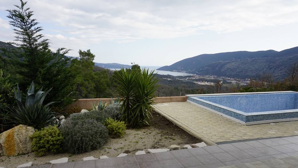 Piscine extérieure dans une villa à Igalo, Monténégro, avec vue panoramique sur les montagnes et la baie de Kotor, aménagement paysager.