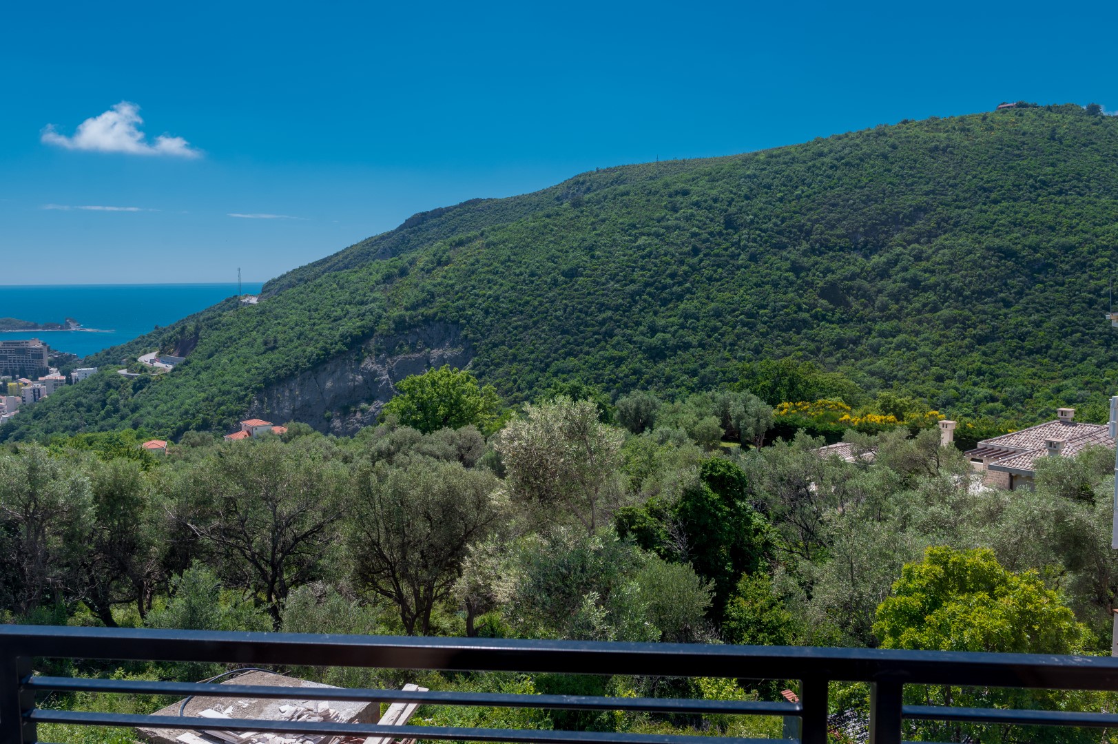 Blick vom Balkon der Villa in Bečići, Montenegro: Panorama auf grüne Berge, Olivenbäume und die Adria.