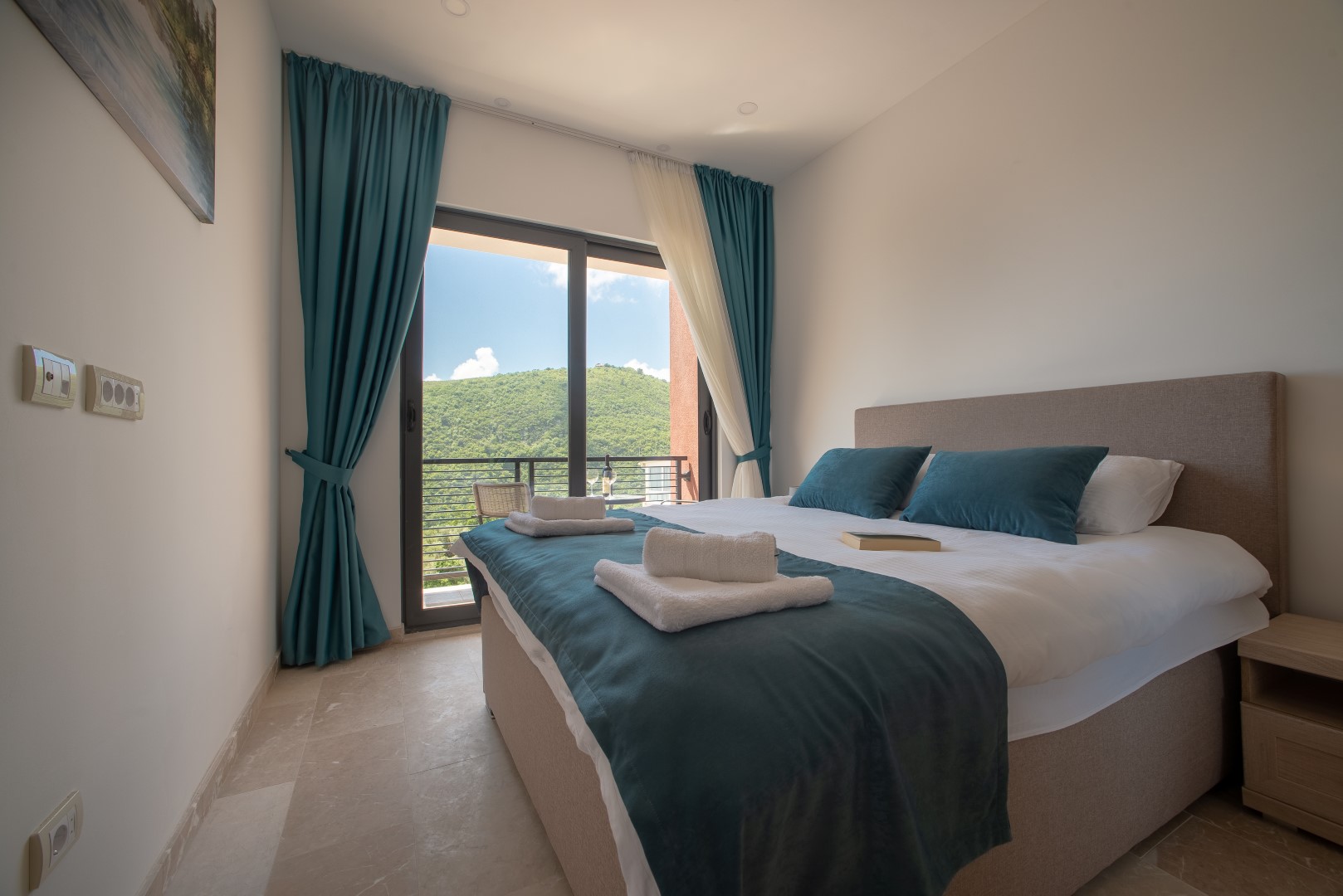 Schlafzimmer mit Doppelbett und Bergblick in einer Villa in Bečići, Montenegro: modernes Interieur, Panoramafenster.