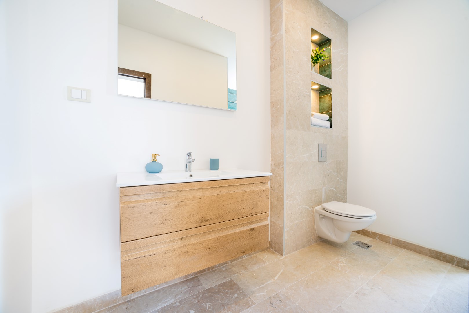 Modernes Badezimmer mit Steinverkleidung und Holzwaschtisch in einer Villa in Bečići, Montenegro.
