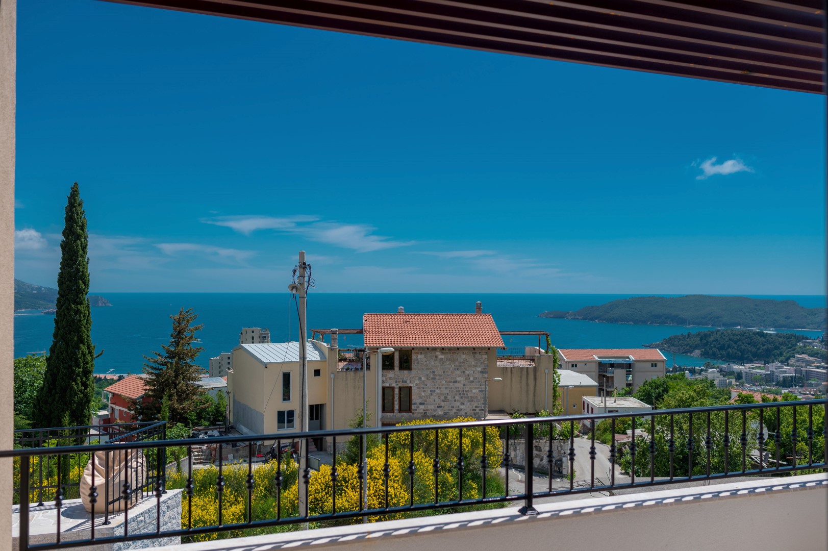 Blick vom Balkon der Villa in Bečići, Montenegro: Panorama der Adria, Berge und Ziegeldächer der Häuser.