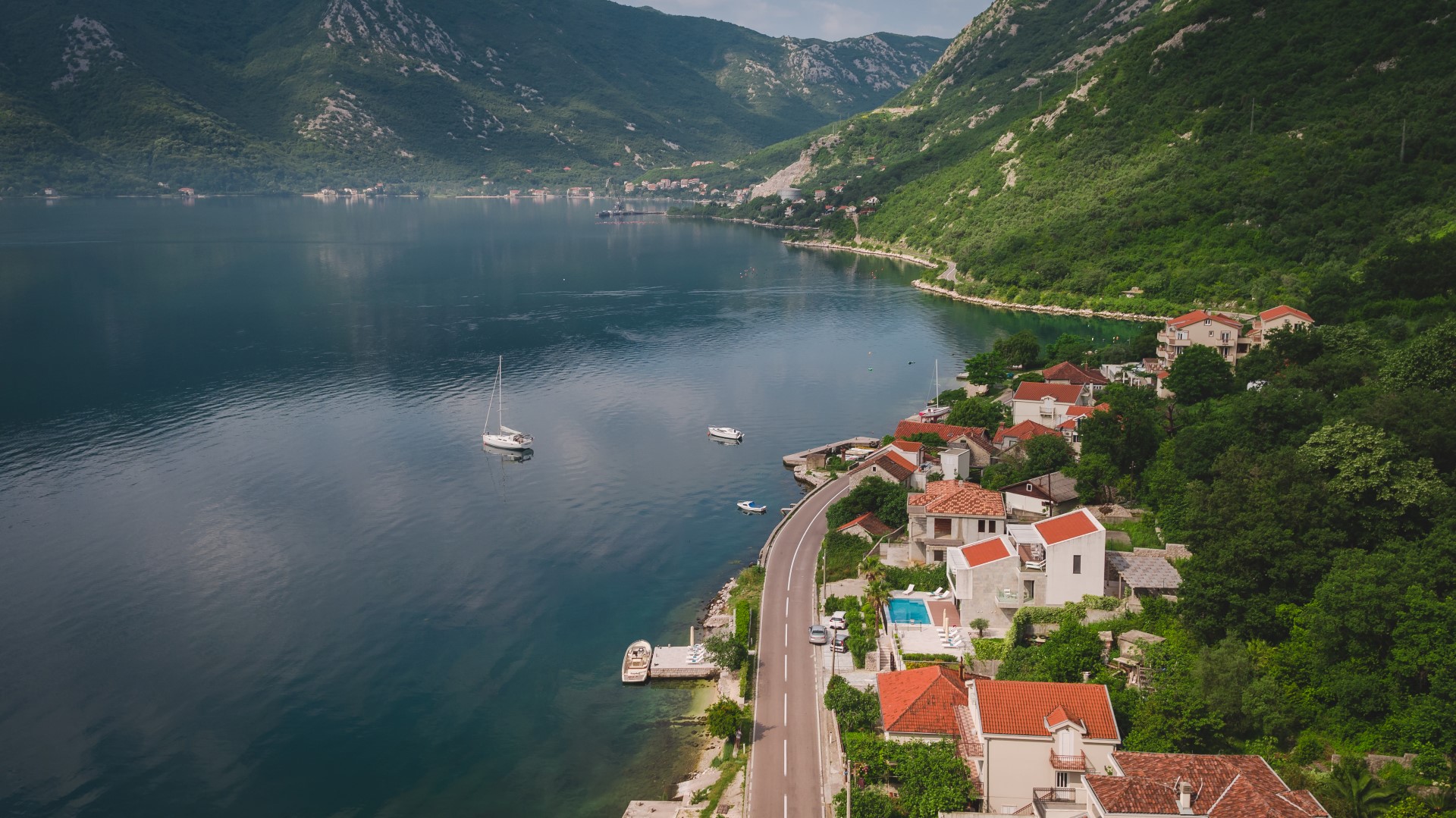 Karadağ, Strp’te villanın havadan görünümü: havuzlu, teraslı ve Kotor Körfezi’ne panoramik manzaralı sahil evi.
