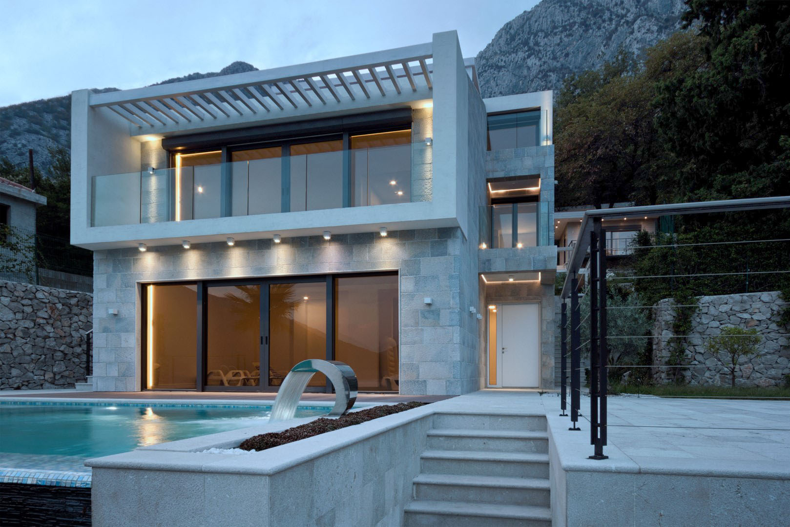 Karadağ, Strp köyünde havuzlu ve taş cepheli modern villa, akşam dış görünüm.