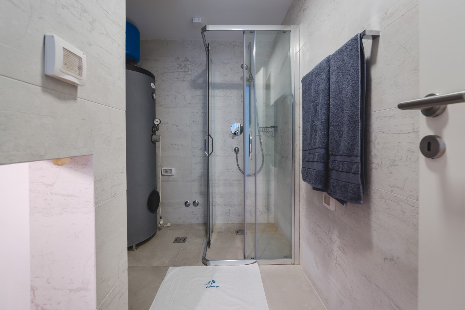 Strep, Karadağ’daki villada duş kabini ve бойлер bulunan modern banyo. Açık renkli fayans kaplama.