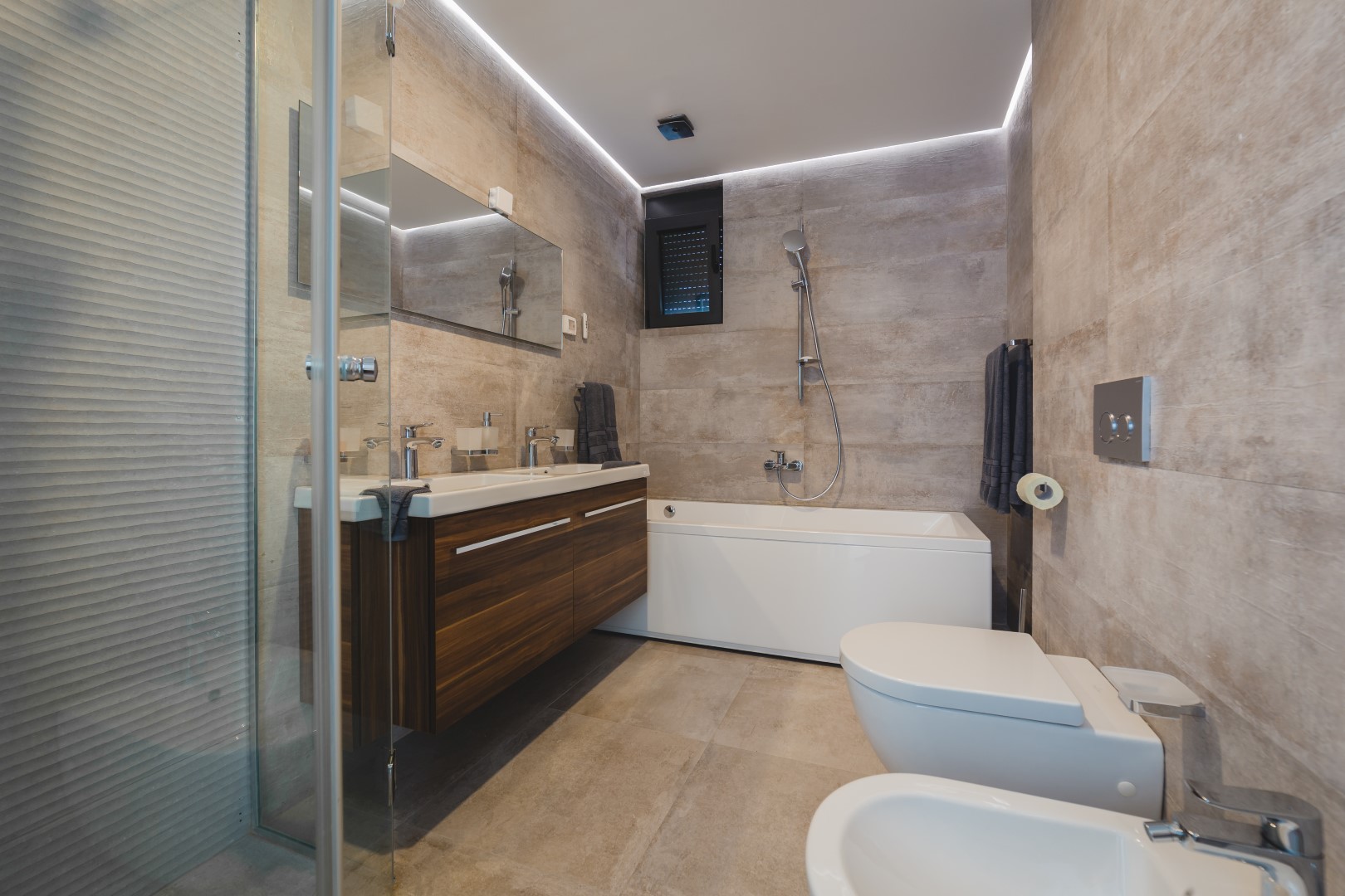 Villa, Strp, Karadağ’da küvet ve duşlu modern banyo: taş görünümlü şık kaplama ve ahşap mobilyalar.