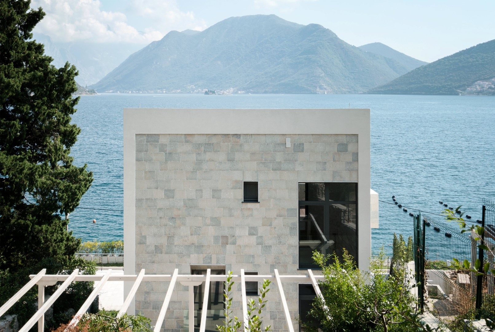 Karadağ, Strp’te Kotor Körfezi kıyısında, deniz ve dağların panoramik manzarasına sahip modern taş villa.