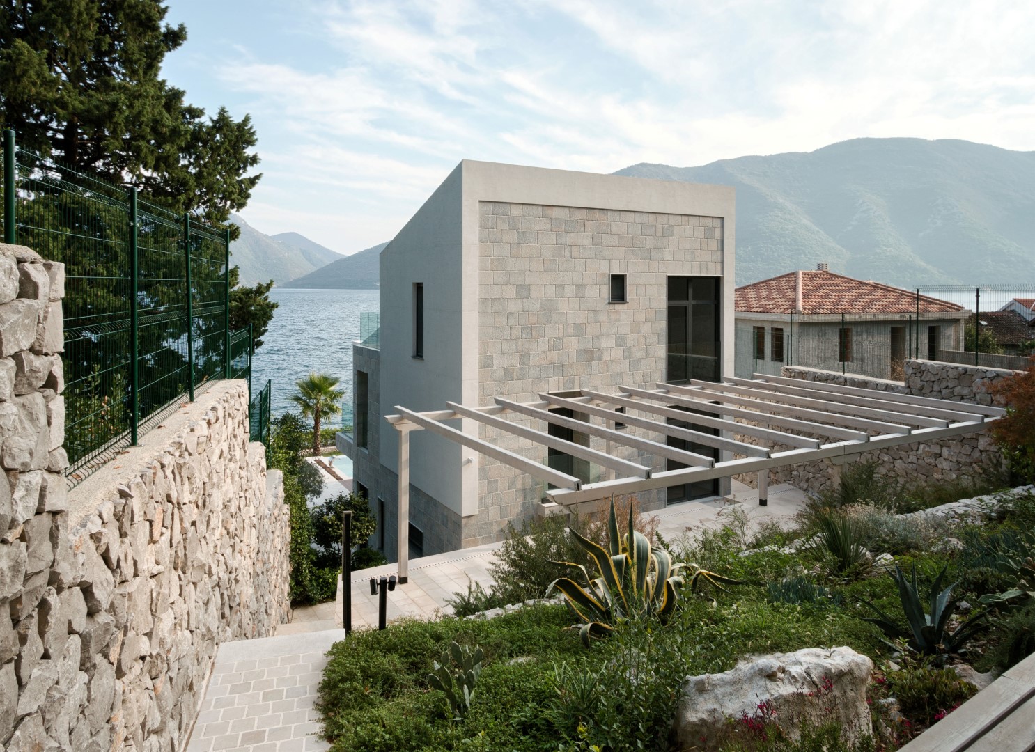 Karadağ’ın Strp köyünde, teraslı ve deniz manzaralı, peyzajlı bir bahçe ile çevrili modern taş villa.