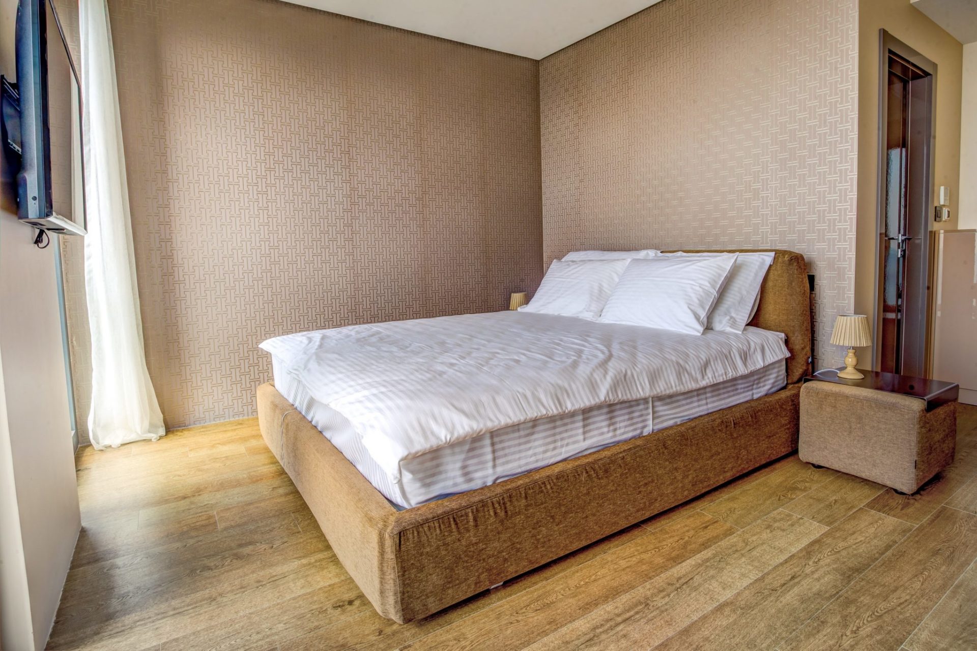 Gemütliches Schlafzimmer mit Doppelbett und Einrichtung in Beigetönen in einer Villa in Budva, Montenegro.