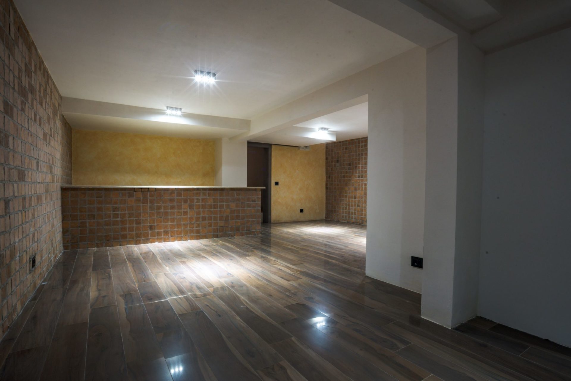 Wohnzimmer mit Bartheke, Ziegelverkleidung und Holzoptikfliesen in einer Villa in Budva, Montenegro.